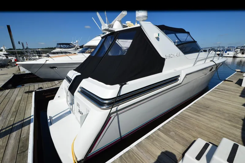 Slide: The Image of Luxury 1991 Baron 43-E yacht docked at marina under clear blue sky. - 4