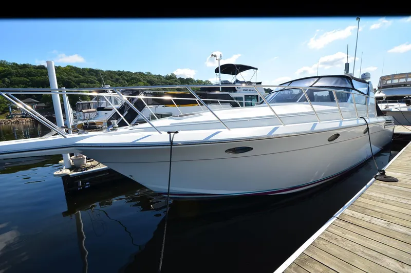 Slide: The Image of 1991 Baron 43-E yacht docked at marina, clear sky, calm water. - 6
