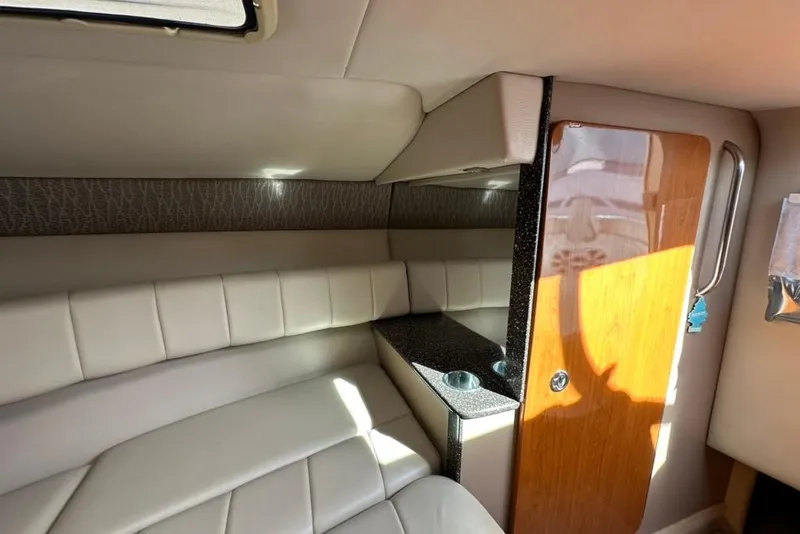 Slide: The Image of 2005 Formula 280 Sun Sport cabin interior with cushioned seating and wooden accents. - 15