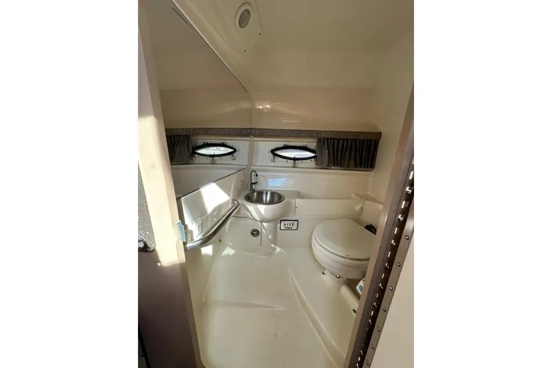 Slide: The Image of 2005 Formula 280 Sun Sport boat bathroom with sink, toilet, and porthole windows. - 17