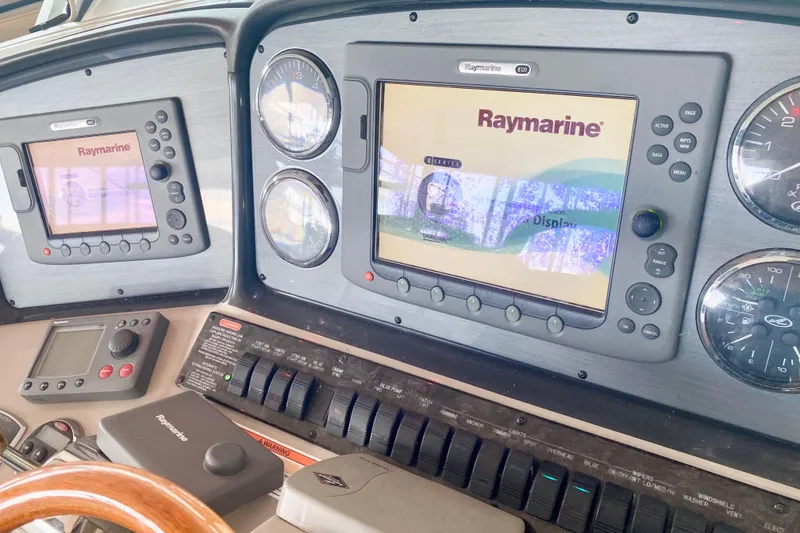 Slide: The Image of 2007 Sea Ray 38 Sundancer dashboard with Raymarine navigation displays and controls. - 17
