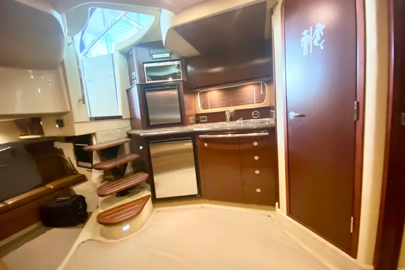 Slide: The Image of Interior of 2007 Sea Ray 38 Sundancer yacht with kitchenette and wooden cabinetry. - 23