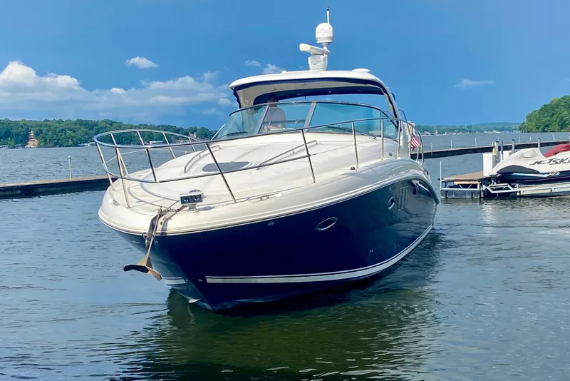 Slide: The Image of 2007 Sea Ray 38 Sundancer yacht docked on a serene lake under a clear blue sky. - 5