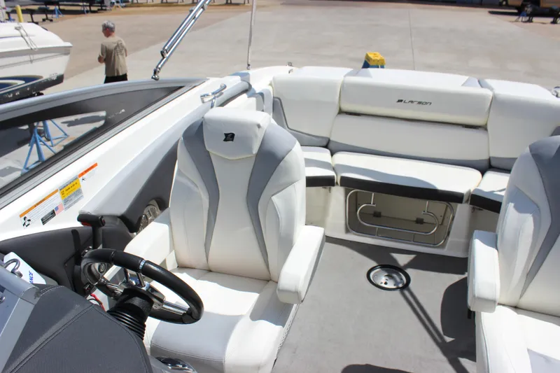 Slide: The Image of 2014 Larson LXi 258 IO boat interior with white seating and steering wheel. - 23