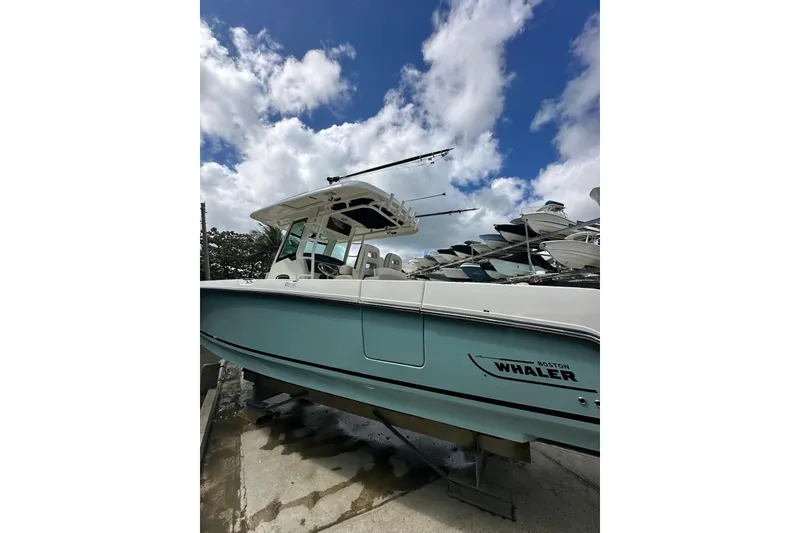 Slide: The Image of 2022 Boston Whaler 330 Outrage boat under a partly cloudy sky. - 15