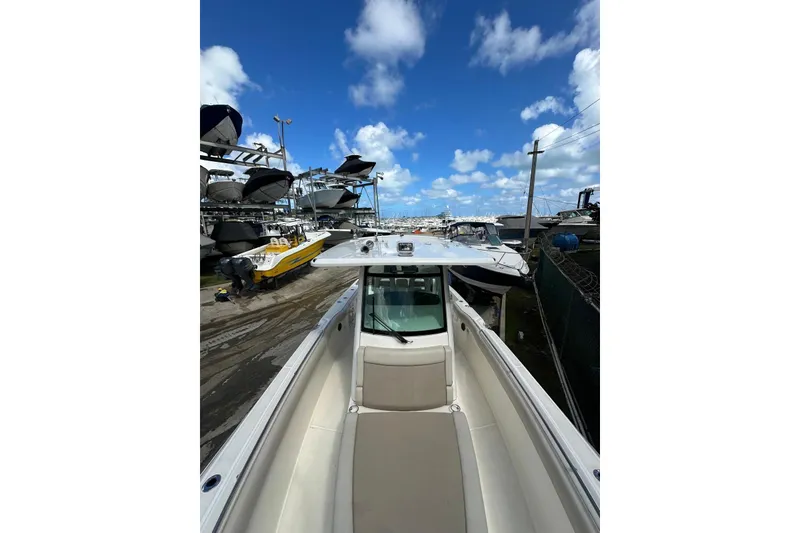 Slide: The Image of 2022 Boston Whaler 330 Outrage boat docked under a clear blue sky. - 2