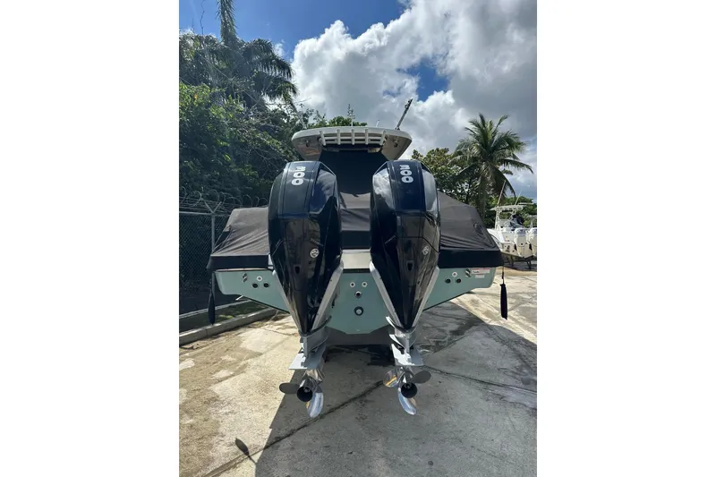 Slide: The Image of 2022 Boston Whaler 330 Outrage with dual outboard engines, docked outdoors. - 5