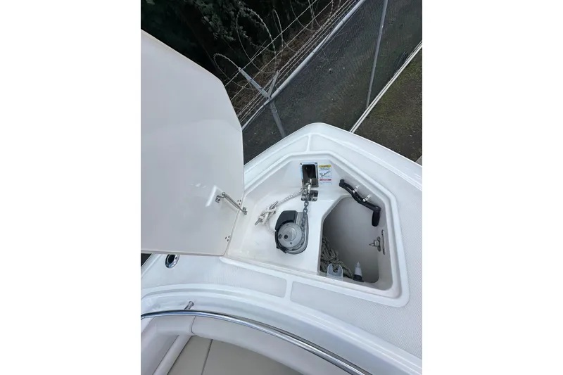 Slide: The Image of 2022 Boston Whaler 330 Outrage anchor compartment with open hatch and visible equipment. - 7
