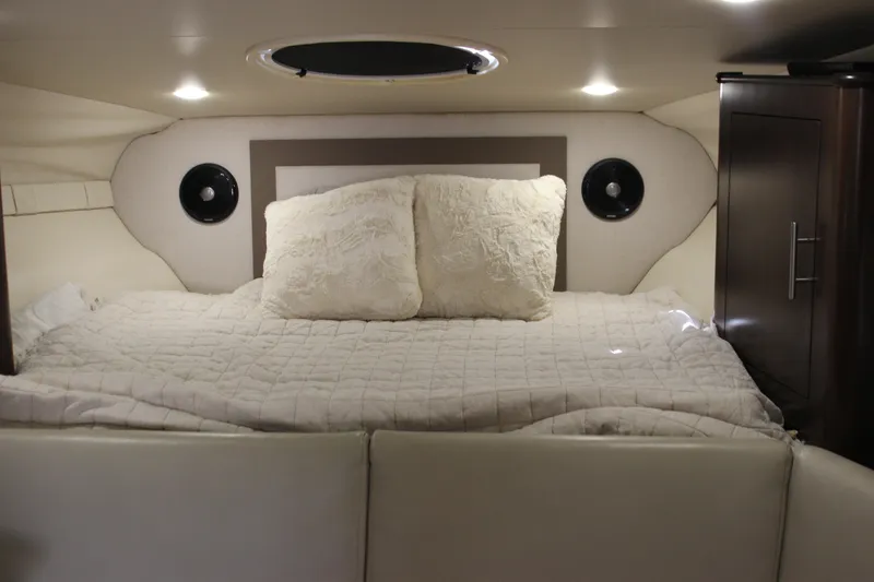 Slide: The Image of Cozy cabin interior of 2014 Regal 32 Express with plush bedding and ambient lighting. - 16