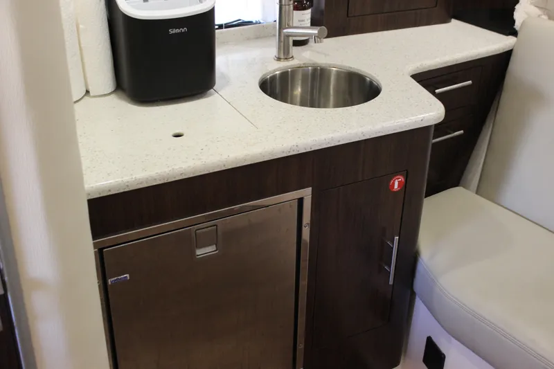 Slide: The Image of 2014 Regal 32 Express yacht interior with kitchenette, sink, and storage cabinets. - 19