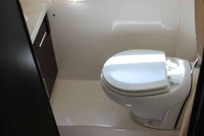 Slide: The Image of 2014 Regal 32 Express boat bathroom with modern toilet and dark cabinetry. - 25