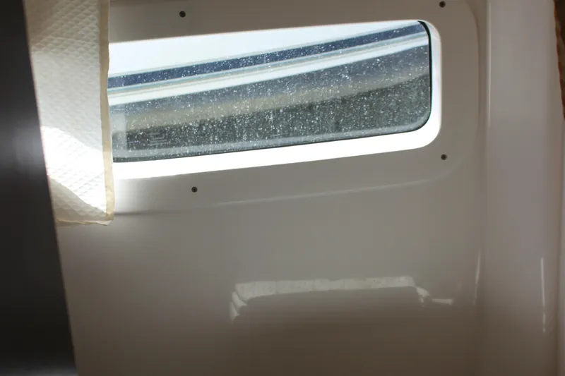 Slide: The Image of Cabin window of a 2014 Regal 32 Express boat, with curtain partially drawn. - 29