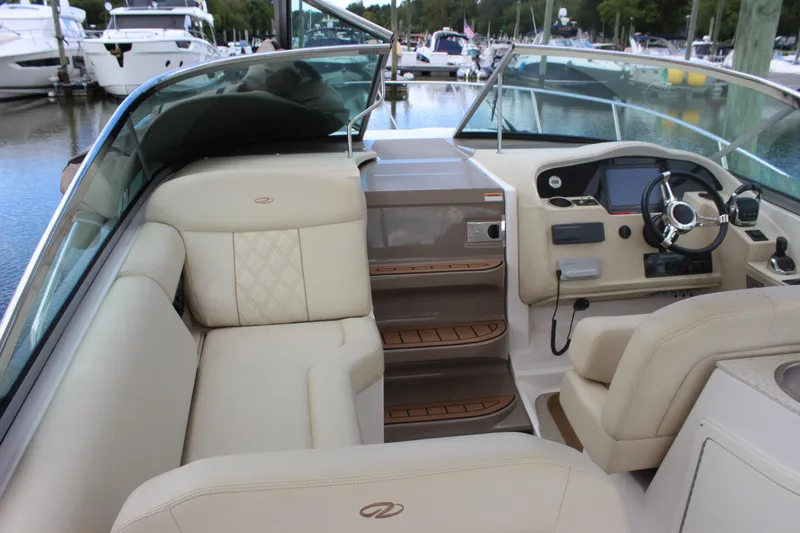 Slide: The Image of 2014 Regal 32 Express boat interior with beige seating and modern dashboard at marina. - 39