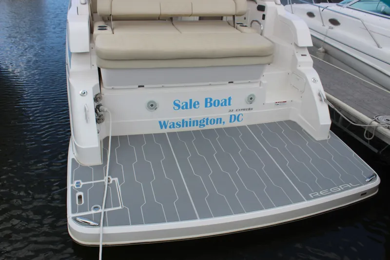 Slide: The Image of 2014 Regal 32 Express boat docked, featuring spacious seating and sleek design. - 4