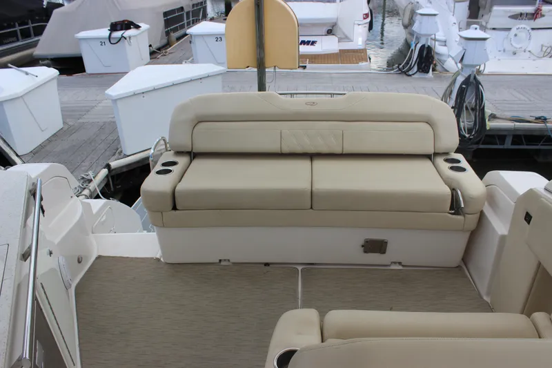 Slide: The Image of 2014 Regal 32 Express boat interior with beige seating and cup holders at dock. - 41