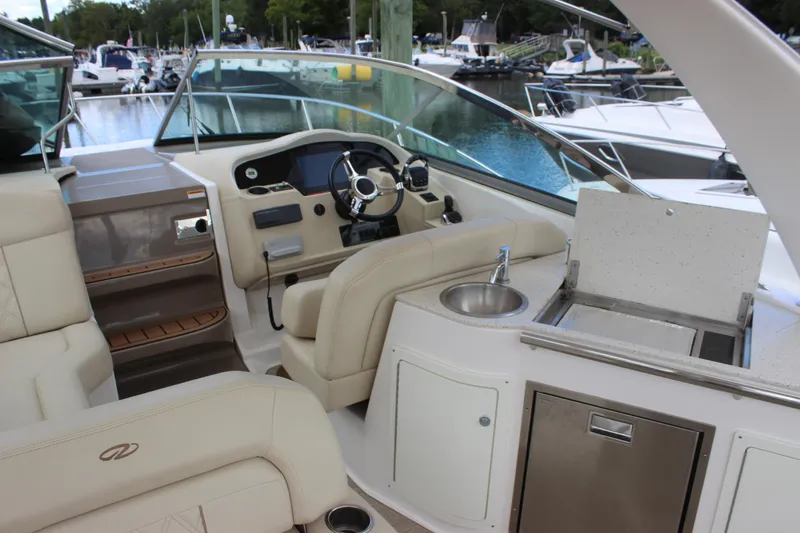 Slide: The Image of 2014 Regal 32 Express boat interior with helm, seating, and kitchenette. - 43
