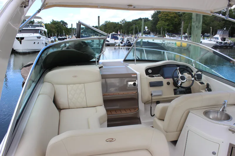 Slide: The Image of 2014 Regal 32 Express boat interior with helm, seating, and marina view. - 44