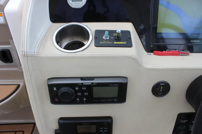 Slide: The Image of 2014 Regal 32 Express dashboard with Garmin display, Fusion audio system, and Marinco spotlight controls. - 57