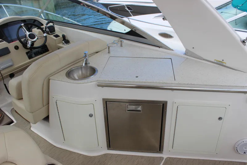 Slide: The Image of 2014 Regal 32 Express boat interior with sink, seating, and storage compartments. - 59