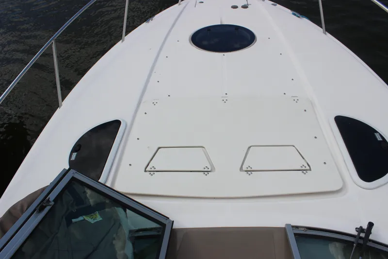 Slide: The Image of 2014 Regal 32 Express boat deck with hatches and railing on water. - 61
