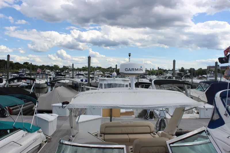 Slide: The Image of Marina with 2014 Regal 32 Express boat, featuring Garmin equipment, under a partly cloudy sky. - 63