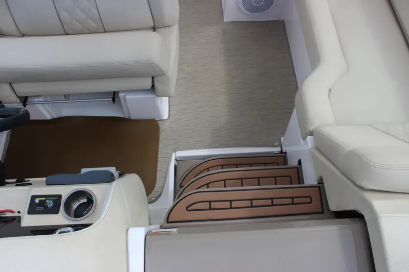 Slide: The Image of Interior view of 2014 Regal 32 Express boat, featuring beige seating and wooden steps. - 67