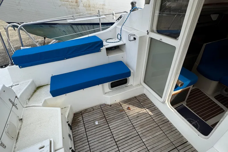 Slide: The Image of 2008 Gemini 105Mc boat interior with blue cushioned seating and wooden flooring. - 12