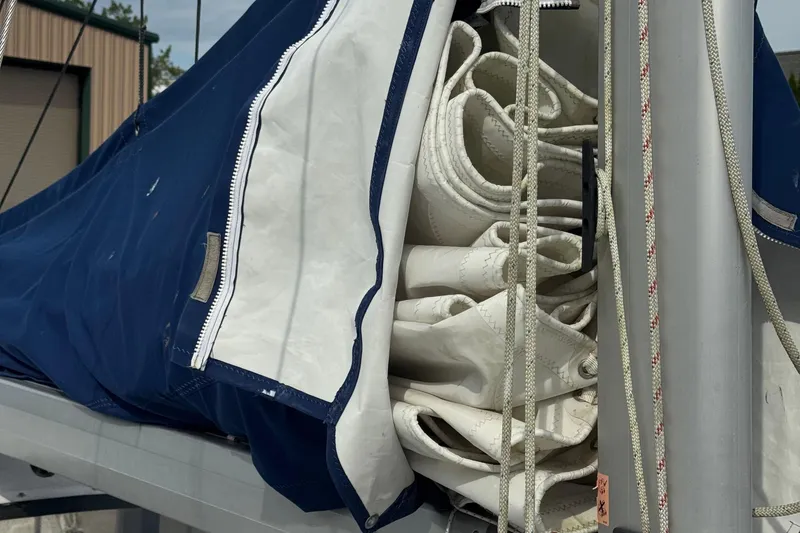 Slide: The Image of Folded sails on a 2008 Gemini 105Mc boat, covered with a blue sail cover. - 13