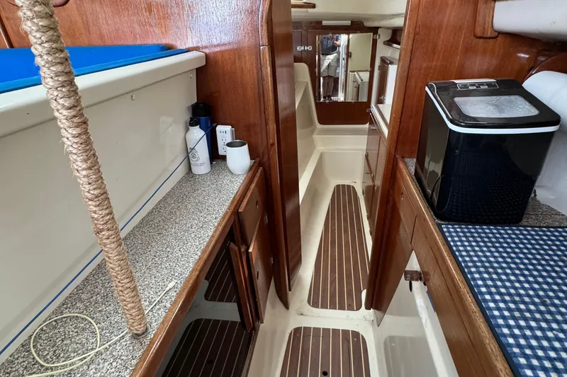 Slide: The Image of Interior of a 2008 Gemini 105Mc sailboat with wood paneling and compact amenities. - 15