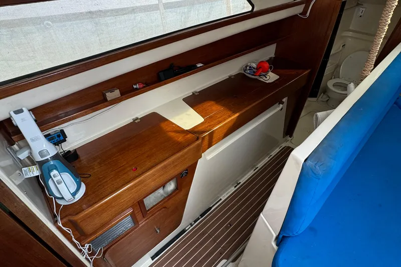Slide: The Image of Interior of 2008 Gemini 105Mc sailboat with wooden cabinetry and blue seating. - 17