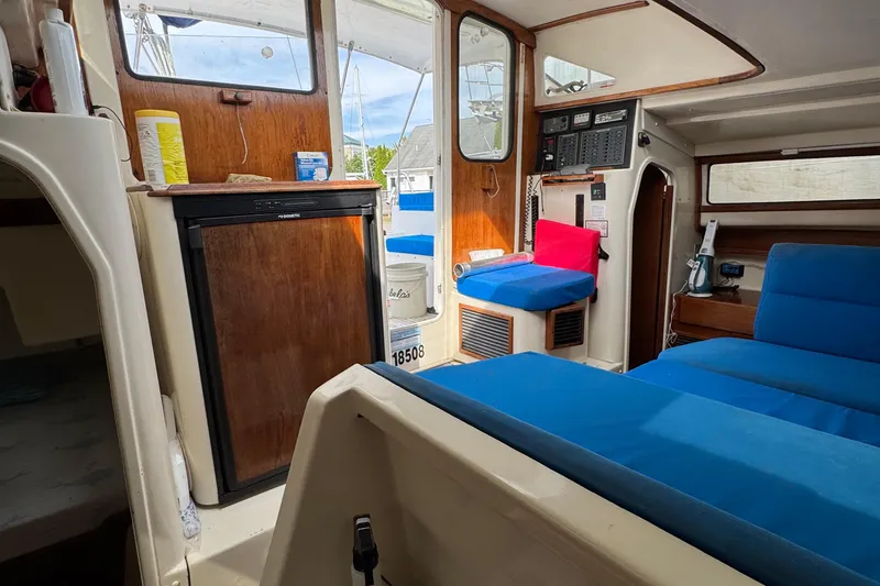 Slide: The Image of Interior of a 2008 Gemini 105Mc sailboat with blue seating and wooden accents. - 18