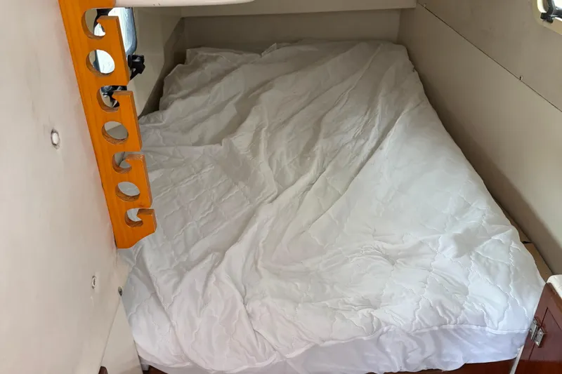 Slide: The Image of Cozy cabin bed in 2008 Gemini 105Mc sailboat, featuring white bedding and wooden accents. - 22