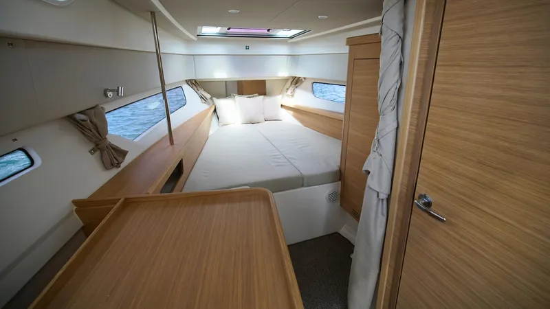 Slide: The Image of Luxurious cabin interior of 2025 Nimbus Weekender 11, featuring a cozy bed and wooden finishes. - 27