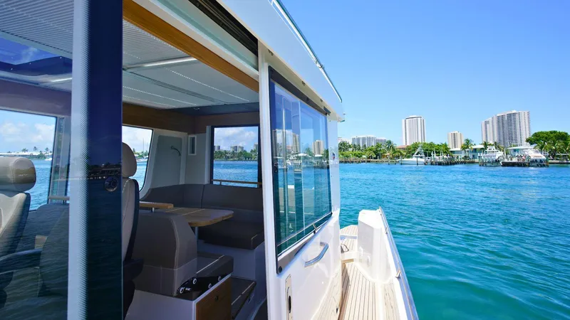 Slide: The Image of 2024 Nimbus Commuter 11 #082 boat on a sunny day with city skyline in the background. - 10