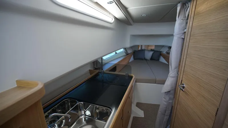 Slide: The Image of 2024 Nimbus Commuter 11 #082 interior with kitchenette and cozy sleeping area. - 23
