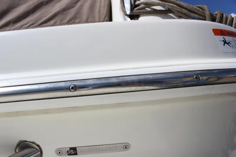 Slide: The Image of 2003 Wellcraft Martinique 2600 boat detail with metal railing and warning sticker. - 11