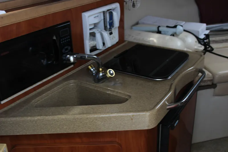 Slide: The Image of 2003 Wellcraft Martinique 2600 boat interior with sink and kitchenette area. - 13