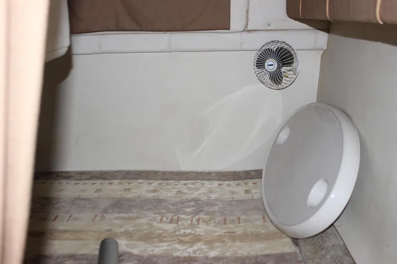 Slide: The Image of 2003 Wellcraft Martinique 2600 cabin interior with fan and circular hatch. - 14