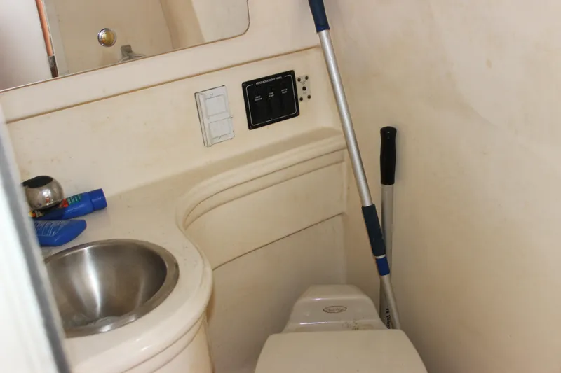 Slide: The Image of 2003 Wellcraft Martinique 2600 boat bathroom with sink, toilet, and cleaning supplies. - 17