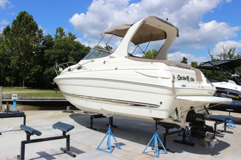 Slide: The Image of 2003 Wellcraft Martinique 2600 boat on stands, outdoors under a blue sky. - 3