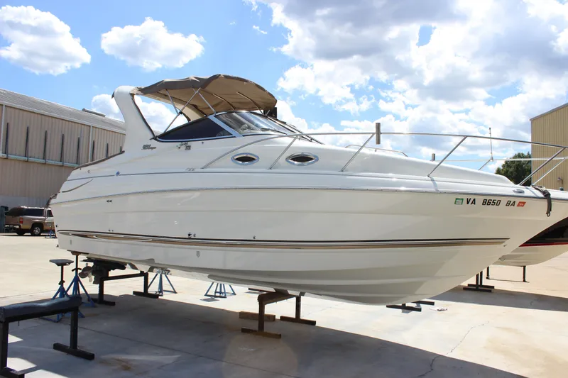Slide: The Image of 2003 Wellcraft Martinique 2600 boat on stands, under a clear blue sky. - 6