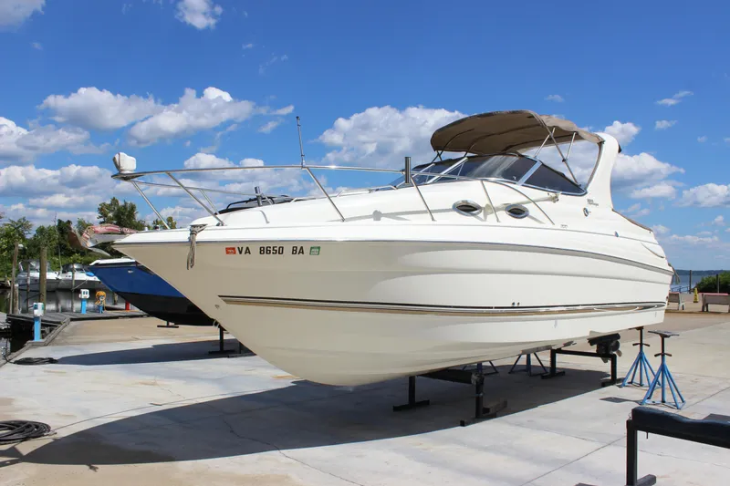 Slide: The Image of 2003 Wellcraft Martinique 2600 boat on stands under a clear blue sky. - 8
