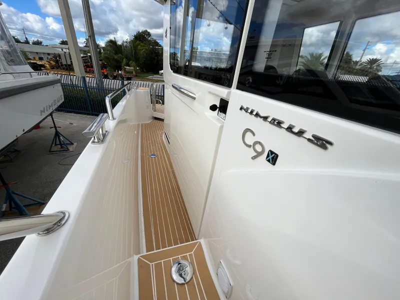 Slide: The Image of 2024 Nimbus Commuter 9 #136 boat exterior with teak deck and sleek design. - 16