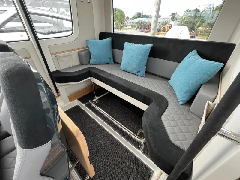 Slide: The Image of 2024 Nimbus Commuter 9 #136 interior with L-shaped seating and blue cushions. - 21
