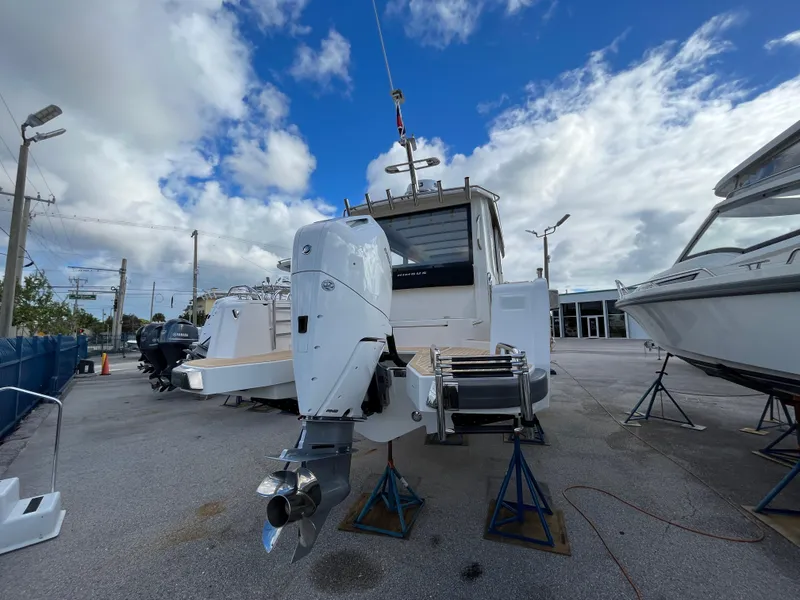 Slide: The Image of 2024 Nimbus Commuter 9 #136 boat on stands, rear view with outboard motor. - 3