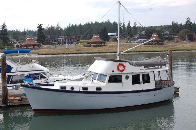 The Image of 1981 Willard Marine Pilot House Trawler docked in a scenic marina setting. - 0