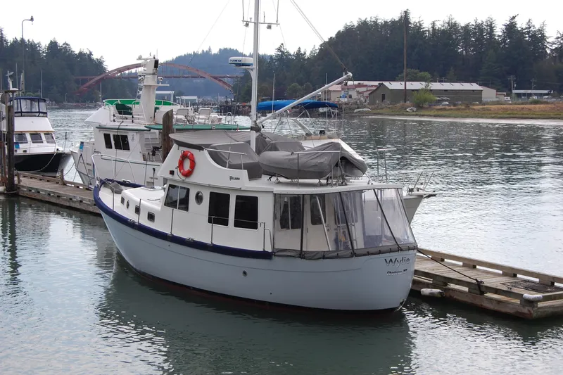 Slide: The Image of 1981 Willard Marine Pilot House Trawler docked in a serene marina setting. - 1
