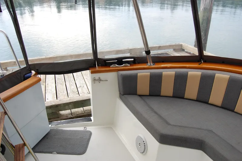 Slide: The Image of Interior of 1981 Willard Marine Pilot House Trawler with cushioned seating and dock view. - 14