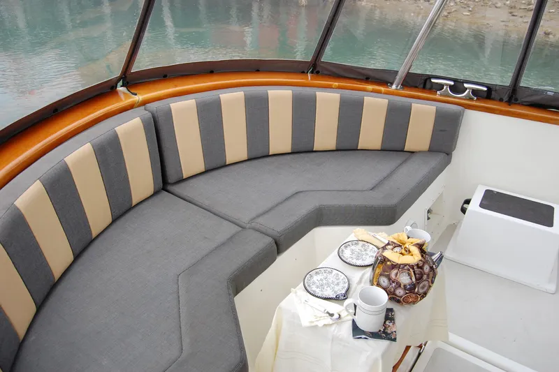 Slide: The Image of 1981 Willard Marine Pilot House Trawler interior with striped seating and a table set for tea. - 16