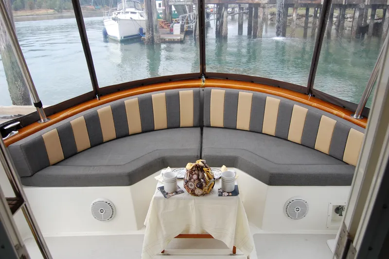 Slide: The Image of Cozy seating area on 1981 Willard Marine Pilot House Trawler with table and scenic water view. - 17